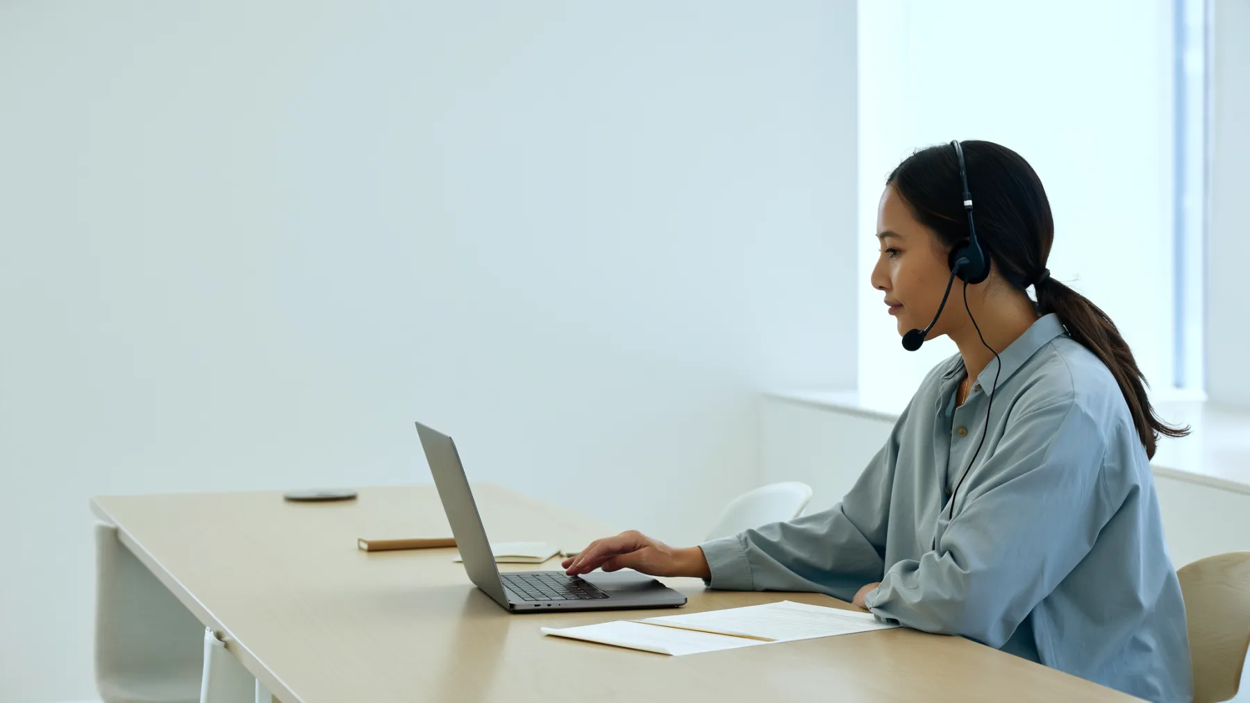 A researcher listening to an interview recording at her desk